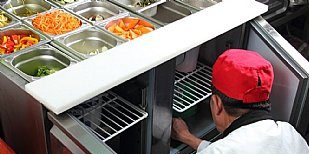 Mitarbeiter einer Großküche bei der Vorbereitung von frischen Lebensmitteln