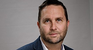 Porträt eines Mannes vor neutralem grauen Hintergrund