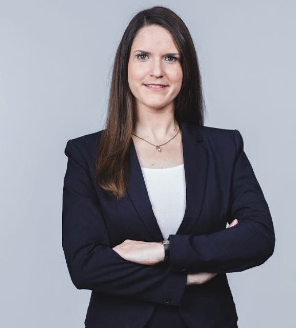Porträt einer Frau im Blazer vor neutralem grauem Hintergrund