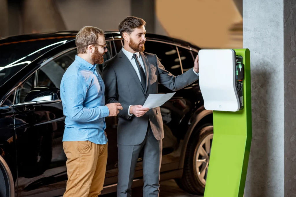Zwei Männer stehen vor einem Auto und beraten sich