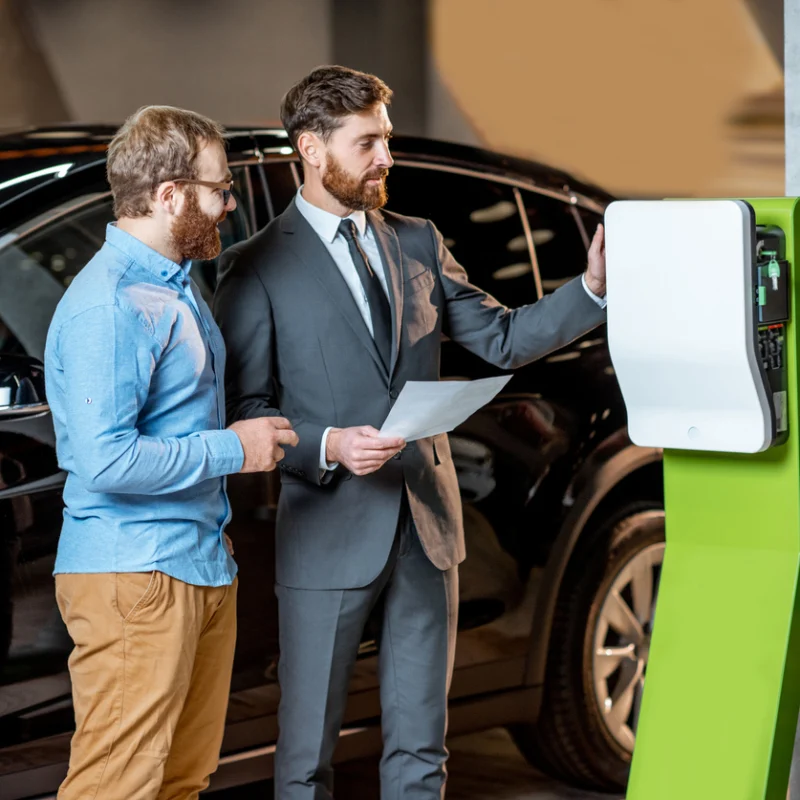 Zwei Männer stehen vor einem Auto und beraten sich