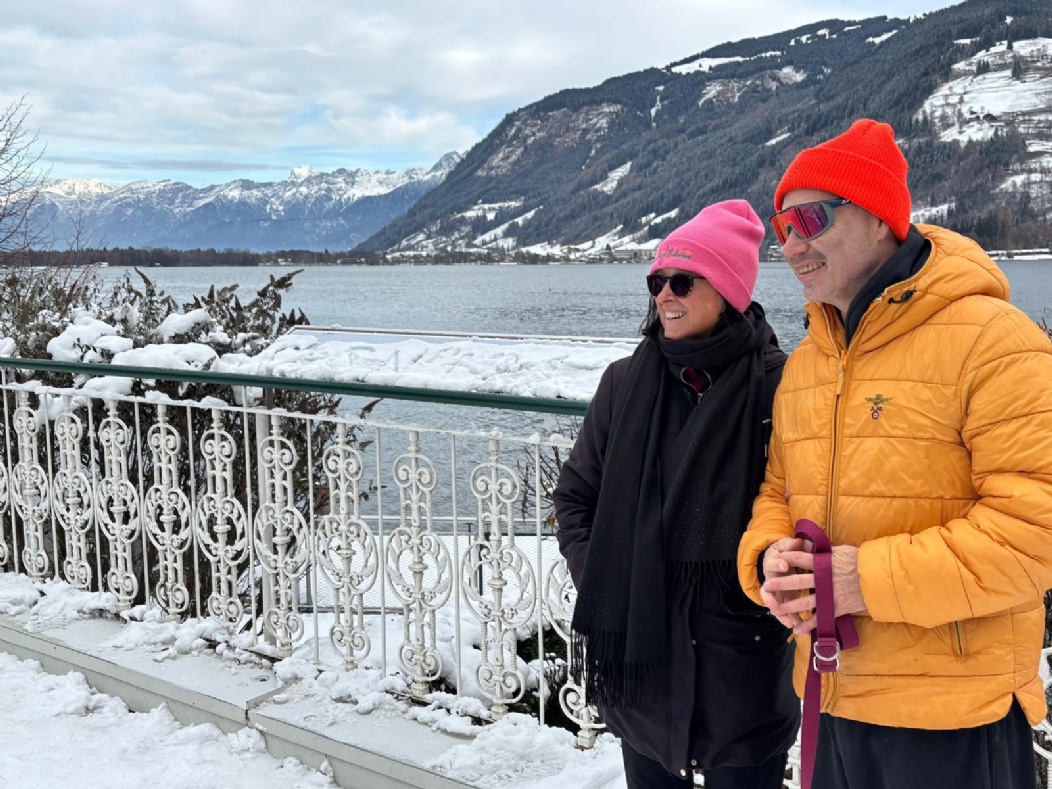 Zwei Personen in Winterkleidung vor verschneiter Berglandschaft