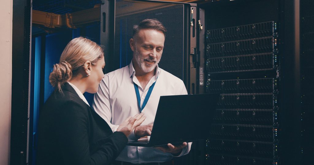 Laptop, Zusammenarbeit und Mitarbeiter im Serverraum für technischen Support, Datenbanken oder Cybersicherheit. Computer, Teamarbeit und Techniker bei der Systemaktualisierung im Rechenzentrum für die Netzwerkprogrammierung.