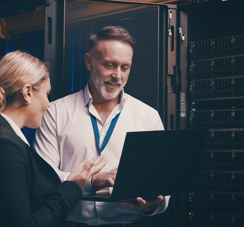Laptop, Zusammenarbeit und Mitarbeiter im Serverraum für technischen Support, Datenbanken oder Cybersicherheit. Computer, Teamarbeit und Techniker bei der Systemaktualisierung im Rechenzentrum für die Netzwerkprogrammierung.